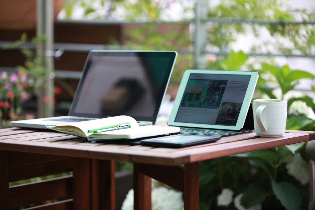 Laptop, tablet, and notebook on a desk